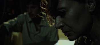 Movie still from “Three Monkeys” (2008), directed by Nuri Bilge Ceylan – A person's face in a dark room; Close Up shot, Low angle