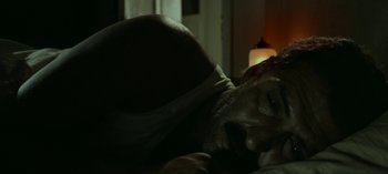 Movie still from “Three Monkeys” (2008), directed by Nuri Bilge Ceylan – A man laying on a bed in the dark; Close Up shot, High angle