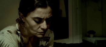 Movie still from “Three Monkeys” (2008), directed by Nuri Bilge Ceylan – A person sitting on a couch; Close Up shot, High angle