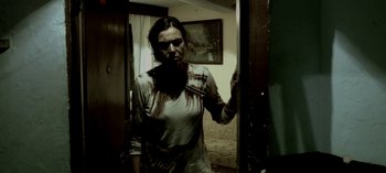 Movie still from “Three Monkeys” (2008), directed by Nuri Bilge Ceylan – A woman standing in front of an open door in a room; Medium shot, Low angle