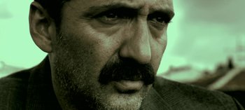Movie still from “Three Monkeys” (2008), directed by Nuri Bilge Ceylan – A person with a mustache; Extreme Close Up shot, Low angle