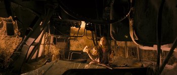 Movie still from “Tideland” (2005), directed by Terry Gilliam – A little girl sitting under a train engine; Medium shot, High angle