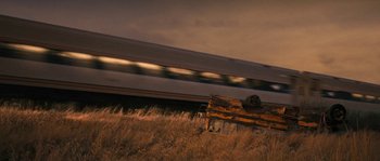 Movie still from “Tideland” (2005), directed by Terry Gilliam – A train traveling down train tracks next to a field; Extreme Wide shot, Low angle
