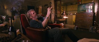 A man sitting in a chair holding a cell phone