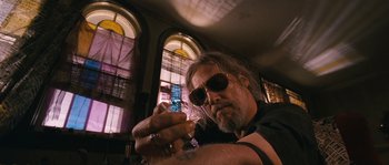 Movie still from “Tideland” (2005), directed by Terry Gilliam – A man with a beard and sunglasses is holding something in his hand; Close Up shot, Low angle