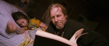 Movie still from “Tideland” (2005), directed by Terry Gilliam – A man with long hair and a goatee is looking at a book; Medium shot, Low angle