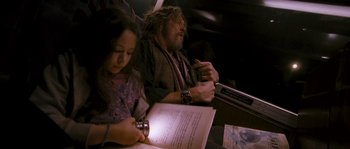 Movie still from “Tideland” (2005), directed by Terry Gilliam – A man sitting next to a woman on a train; Medium shot, High angle