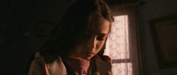 Movie still from “Tideland” (2005), directed by Terry Gilliam – A young girl is looking down at her cell phone; Close Up shot, High angle