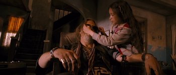 Movie still from “Tideland” (2005), directed by Terry Gilliam – A man sitting in a chair while a girl is sitting on his lap; Close Up shot, Over the shoulder angle
