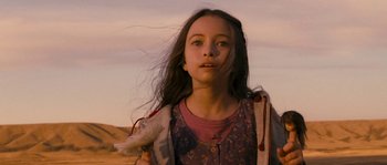 Movie still from “Tideland” (2005), directed by Terry Gilliam – A young girl with long dark hair is standing in the desert; Close Up shot, Low angle