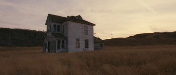 Movie still from “Tideland” (2005), directed by Terry Gilliam – An old house in the middle of a dry grass field; Extreme Wide shot, Low angle