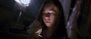 Movie still from “Tideland” (2005), directed by Terry Gilliam – A young girl holding a feather duster in a dark room; Close Up shot, Low angle