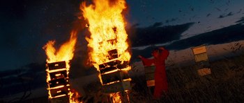 Movie still from “Tideland” (2005), directed by Terry Gilliam – A man standing in front of a fire with boxes; Extreme Wide shot, Low angle