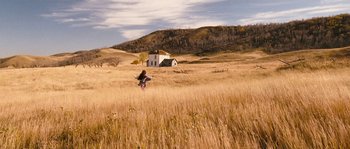 Movie still from “Tideland” (2005), directed by Terry Gilliam – A person flying a kite in the middle of a field; Extreme Wide shot, High angle