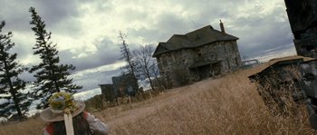 Movie still from “Tideland” (2005), directed by Terry Gilliam – An old stone house in the middle of a dry grass field; Wide shot, Low angle
