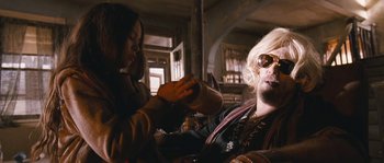 Movie still from “Tideland” (2005), directed by Terry Gilliam – A woman is giving a man a hair cut; Medium shot, Low angle