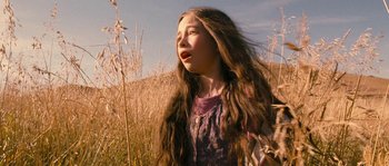 Movie still from “Tideland” (2005), directed by Terry Gilliam – A young girl standing in a field of tall grass; Close Up shot, Low angle