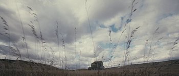 Movie still from “Tideland” (2005), directed by Terry Gilliam – An abandoned house in the middle of a dry grass field; Extreme Wide shot, Low angle
