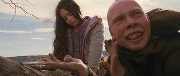 Movie still from “Tideland” (2005), directed by Terry Gilliam – A woman and a man looking at something in a field; Close Up shot, Low angle