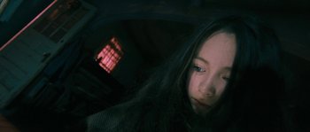 Movie still from “Tideland” (2005), directed by Terry Gilliam – A young girl with long black hair looking at the camera; Close Up shot, High angle