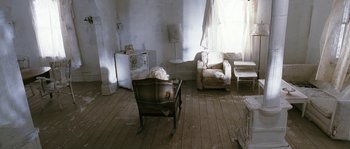 Movie still from “Tideland” (2005), directed by Terry Gilliam – An empty living room with a television and a couch; Wide shot, High angle