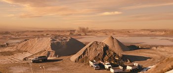 Movie still from “Tideland” (2005), directed by Terry Gilliam – Trucks parked in the sand near a large pile of sand; Extreme Wide shot, High angle