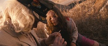 Movie still from “Tideland” (2005), directed by Terry Gilliam – A woman sitting on the ground writing on a piece of paper; Close Up shot, High angle