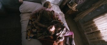 Movie still from “Tideland” (2005), directed by Terry Gilliam – A young girl laying next to an old woman; Medium shot, High angle