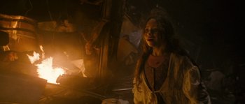 A woman standing next to a fire in a room