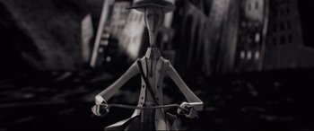 Movie still from “Tigers Are Not Afraid” (2017), directed by Issa López – A black - and - white photo of a toy man riding a bike; Extreme Close Up shot, High angle