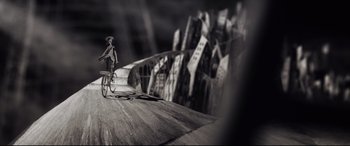 Movie still from “Tigers Are Not Afraid” (2017), directed by Issa López – A person riding a bike on top of a wooden ramp; Extreme Wide shot, High angle