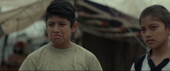 Movie still from “Tigers Are Not Afraid” (2017), directed by Issa López – A young man with a frowning look on his face; Close Up shot, Over the shoulder angle