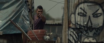 Movie still from “Tigers Are Not Afraid” (2017), directed by Issa López – A man standing on top of a wooden pole; Medium shot, Over the shoulder angle