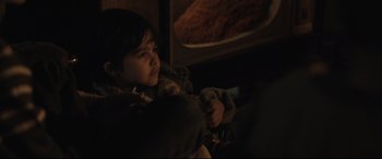 Movie still from “Tigers Are Not Afraid” (2017), directed by Issa López – A young child sitting in a chair in front of a television; Close Up shot, High angle