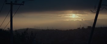 Movie still from “Tigers Are Not Afraid” (2017), directed by Issa López – The sun is setting over a city skyline; Extreme Wide shot, Low angle