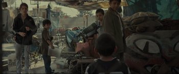 Movie still from “Tigers Are Not Afraid” (2017), directed by Issa López – Two boys are standing in an open market; Medium shot, Over the shoulder angle