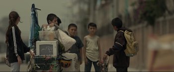 Movie still from “Tigers Are Not Afraid” (2017), directed by Issa López – A group of young men standing next to each other holding skateboards; Wide shot, Low angle