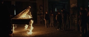 Movie still from “Tigers Are Not Afraid” (2017), directed by Issa López – A group of young people standing around a fire; Extreme Wide shot, High angle