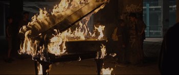 Movie still from “Tigers Are Not Afraid” (2017), directed by Issa López – A piano that has been set on fire; Wide shot, High angle