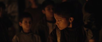 Movie still from “Tigers Are Not Afraid” (2017), directed by Issa López – A young boy is standing in a dark room; Close Up shot, Over the shoulder angle