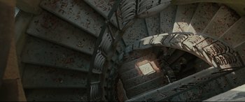 Movie still from “Tigers Are Not Afraid” (2017), directed by Issa López – Looking down at a spiral stair case in a building; Extreme Wide shot, Overhead angle