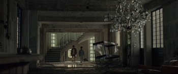 Movie still from “Tigers Are Not Afraid” (2017), directed by Issa López – Two people standing in an abandoned building with stairs; Wide shot, Low angle