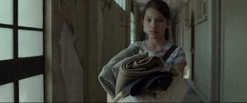 Movie still from “Tigers Are Not Afraid” (2017), directed by Issa López – A young girl is holding a bag of clothes; Medium shot, High angle