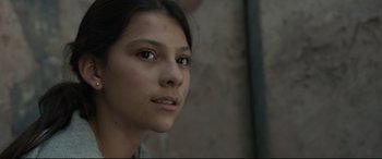 Movie still from “Tigers Are Not Afraid” (2017), directed by Issa López – A young girl looking into the distance with a serious look on her face; Close Up shot, Low angle