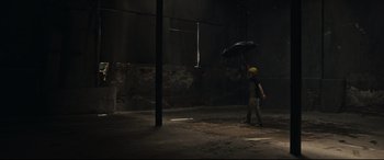 Movie still from “Tigers Are Not Afraid” (2017), directed by Issa López – A man holding an umbrella in a dark room; Wide shot, Low angle