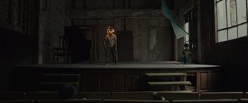 Movie still from “Tigers Are Not Afraid” (2017), directed by Issa López – A man standing on a stage holding a microphone; Wide shot, Low angle