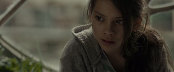 Movie still from “Tigers Are Not Afraid” (2017), directed by Issa López – A young woman wearing a sweater looking at the camera; Close Up shot, Over the shoulder angle