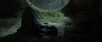 Movie still from “Tigers Are Not Afraid” (2017), directed by Issa López – A blanket is laying on the ground in front of a window; Medium shot, High angle