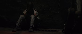 Movie still from “Tigers Are Not Afraid” (2017), directed by Issa López – A person sitting on the ground in front of a wall; Medium shot, High angle