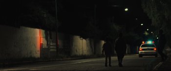 Movie still from “Tigers Are Not Afraid” (2017), directed by Issa López – Two people walking down a street at night; Extreme Wide shot, Low angle